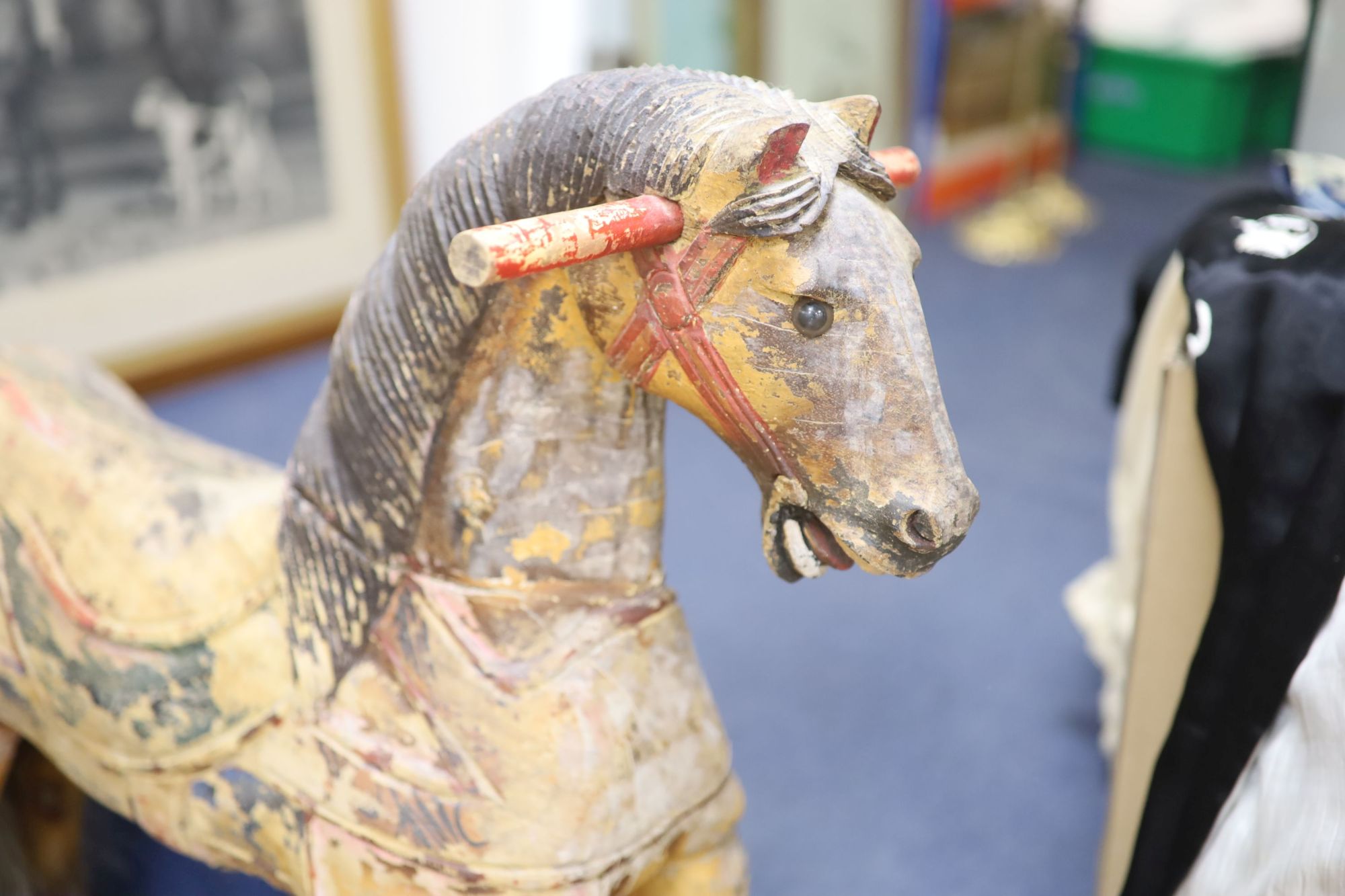 A painted carved wood Merry-go-round horse now in a wheeled base, height 80cm